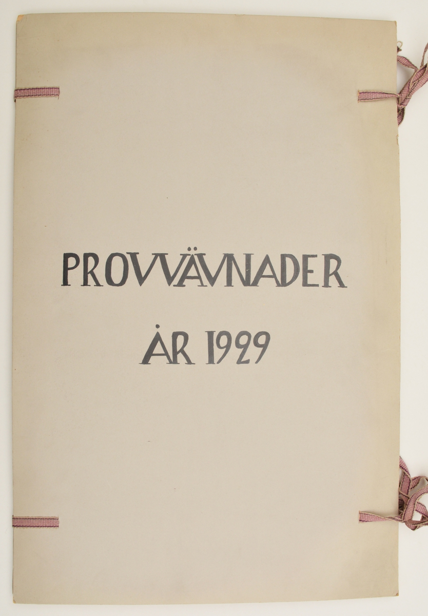 Stor pappersmapp med lösa blad med påklistrade tygprover. Pärmarna är av en annan papperskvalité än papperna innuti. Pärmarna hålls ihop med ett par långa, handvävda band.
Text på framsidan; "Väfprofer År 1929".