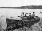 Kvinna och man i motorbåt, sannolikt i Ekoln, Uppland 1920