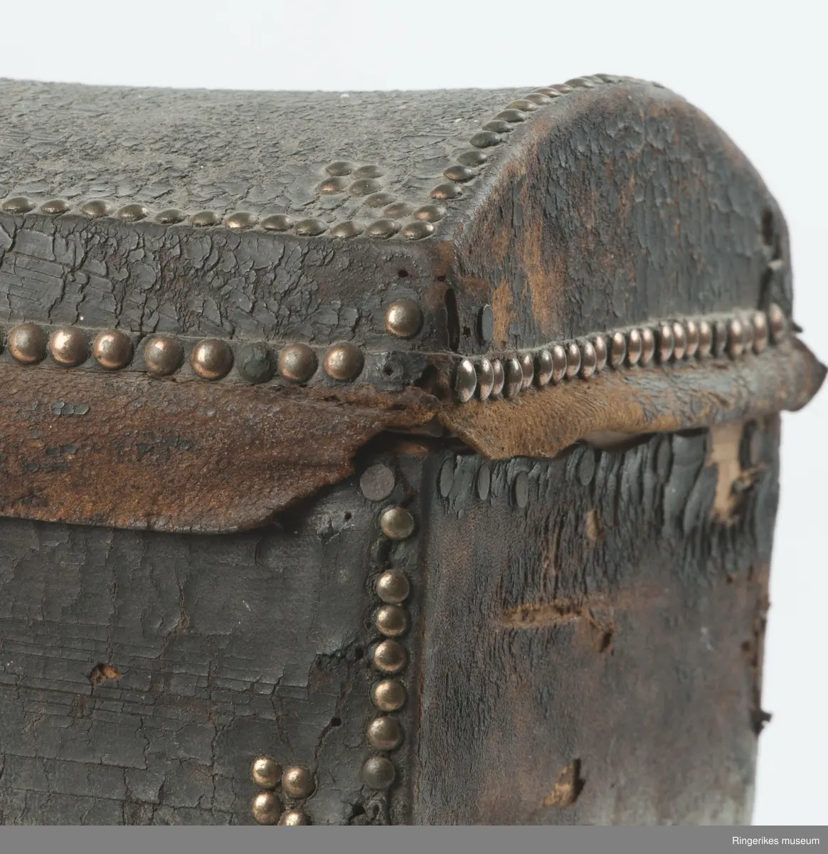 innslåtte kobbernagler langs kante rog hjørner på kasse og lokk som dekor. Prikkei mønster på papir.