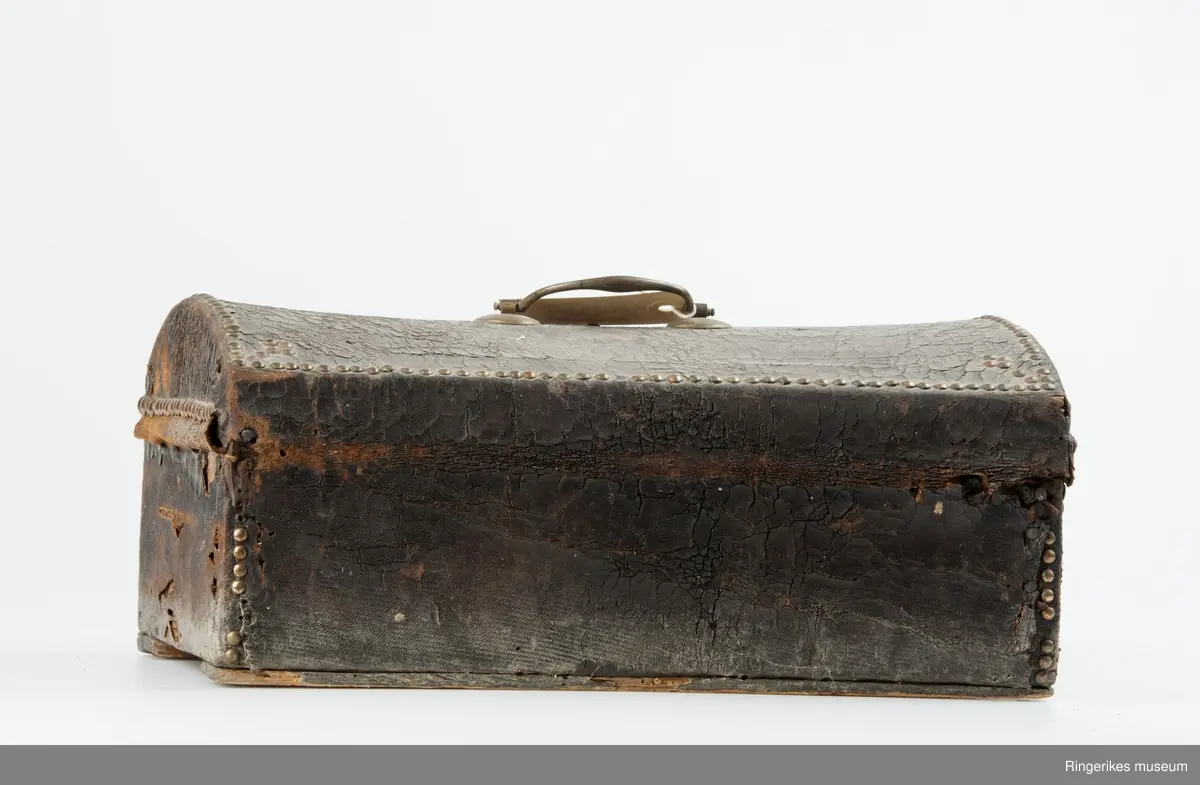 innslåtte kobbernagler langs kante rog hjørner på kasse og lokk som dekor. Prikkei mønster på papir.