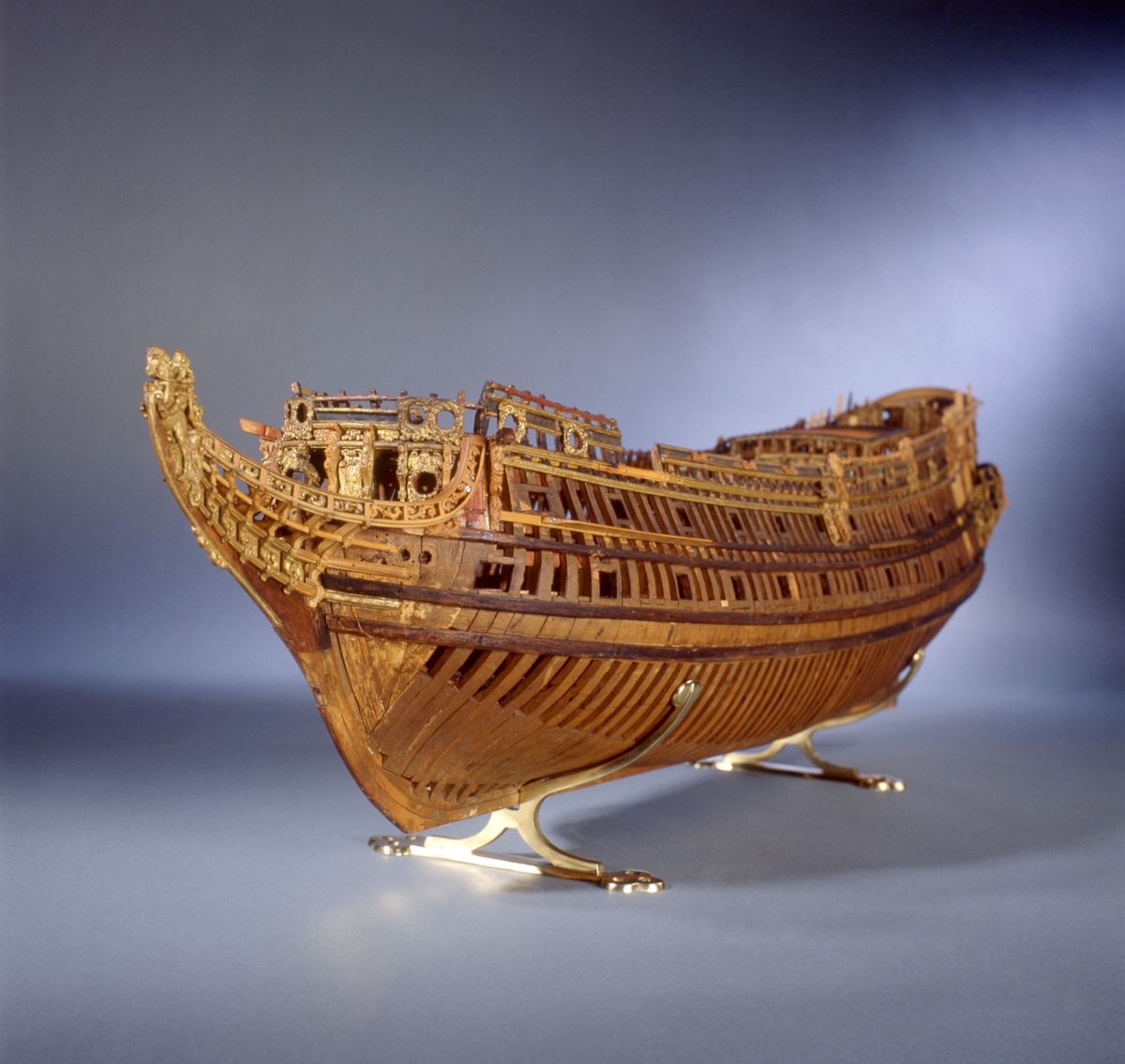 This unplanked model of a three-decker can be dated to c. 1660 and is one of the world's oldest models of a warship. Although not definitively identified, recent research links it to the Swedish ship *Riksäpplet*, designed by the English master shipwright Francis Sheldon and launched in 1661.     
The model was possibly made for Sheldon, who came to Sweden in 1659. He was one of a number of English shipwrights employed by the Swedish crown during the period. Previously, most Swedish warships had been built in the Dutch style.

From around 1660, the English Royal Navy’s administrators commissioned models that were accurately detailed and true to scale. These miniatures, which came to be called Navy or Admiralty Board models, had an unplanked lower hull to emphasise the shape of the underwater body. 

The model was restored by rear-admiral Jacob Hägg in the late 1890s. Missing parts have been reconstructed using lighter coloured wood.

3D model produced by Adam de Kaminski and Vasilis Haroupas for SMTM, 2023
