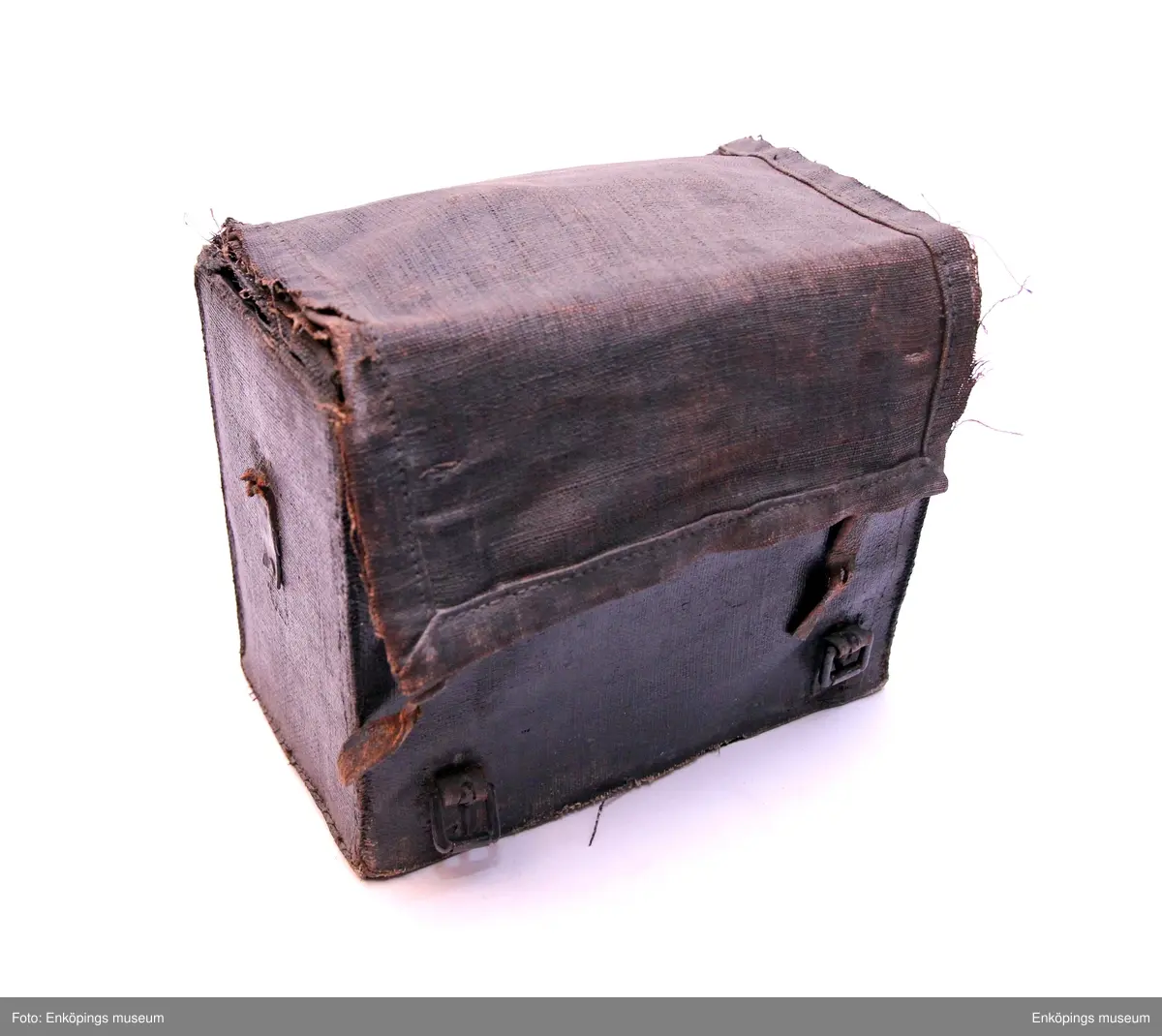 Lådkamera med väska, väskan av duk. Insidan trä klädd med svart sammet. Remmar av läder. Kameralådan av trä klädd med läder. Handtag på ovansidan av läder. Detaljer av metall och glas. Serienummer 3100 på båda kortsidorna. Mitt på ena kortsidan inpräglat märke som dock endast går att tyda- EXPRESS.