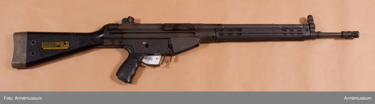 Består av: 1 automatkarbin, 1 gevärsrem av läder m knapp, karbinhake/tilläggshake. Piplängden avser pipa m flamdämpare. Tillv. år 1980-04. Krönt C 04/80. 