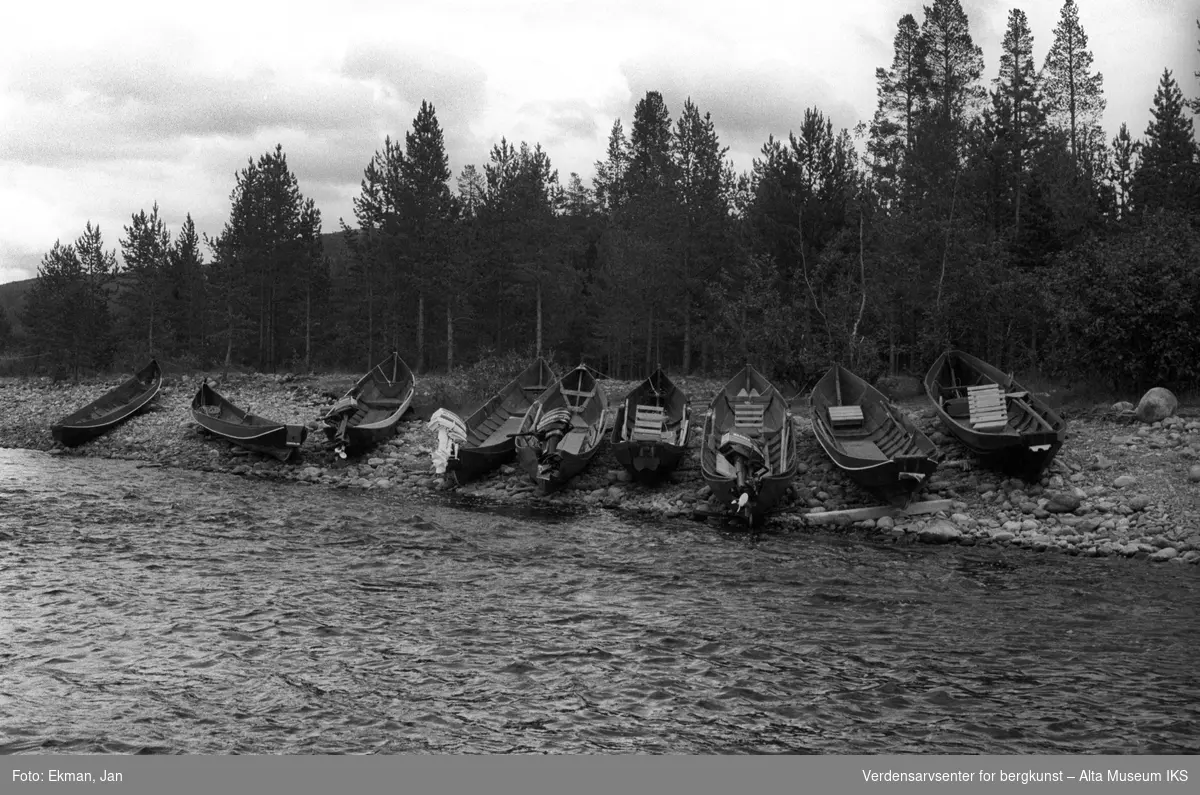 Elvebåt i landskap.

Fotografert mellom 1983 og 1984.

Fotoserie: Laksefiske i Altaelva i perioden 1970-1988 (av Jan Ekman).
