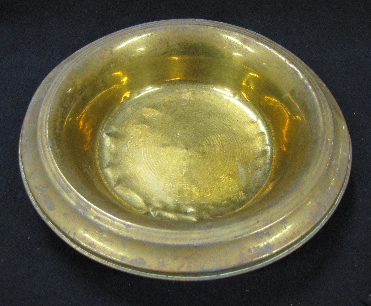 Spottkopp av mässing. Som lock användes ett vitt fat i porslin se VM18769:b.

160 mm. i diam.

Spottkoppen stod i skomakarverstad som ägdes av skomakarmästare Karl Gustav Lundell 1858 - 1923 (far till givaren).