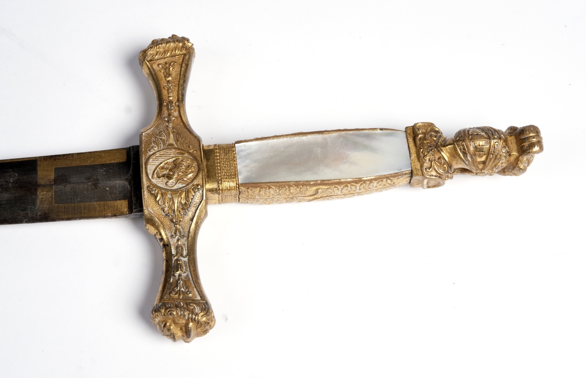 Perlemors-håndtak.  Skjefte m/visirhode, soldat m/gevær, riksvåpen.  Klingen signert " C. M. F. " og  " C XIV J ".
Sliren av lær og messing, liljemerket.