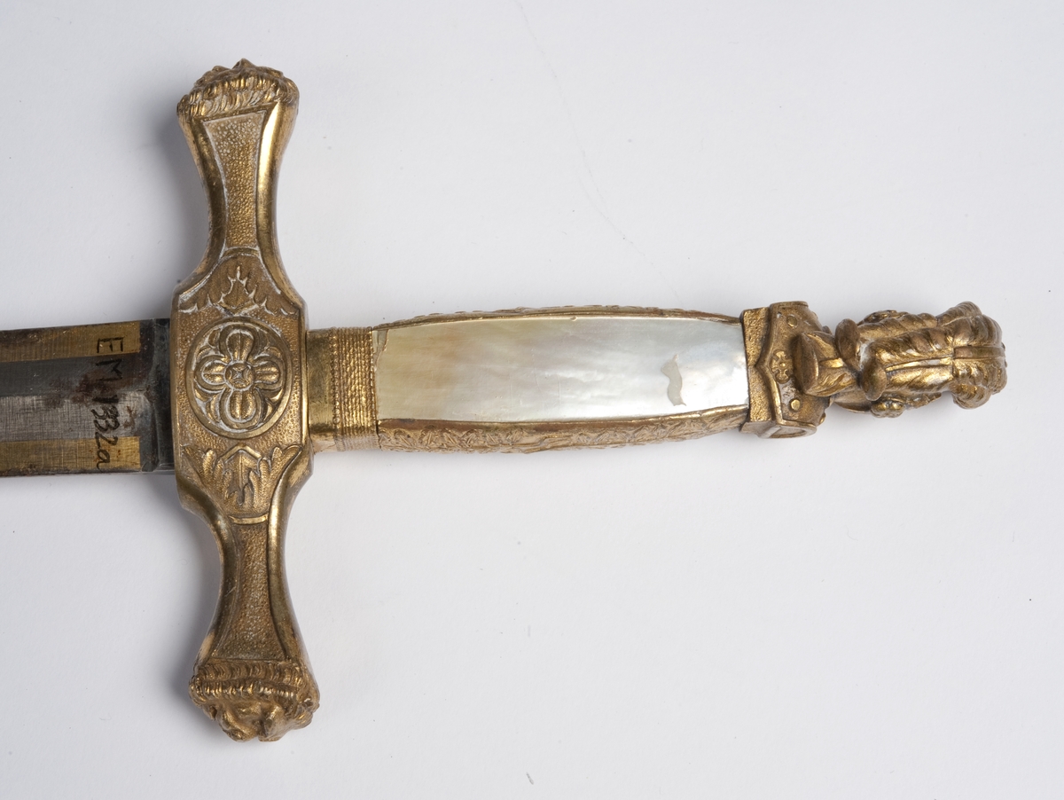 Perlemors-håndtak.  Skjefte m/visirhode, soldat m/gevær, riksvåpen.  Klingen signert " C. M. F. " og  " C XIV J ".
Sliren av lær og messing, liljemerket.