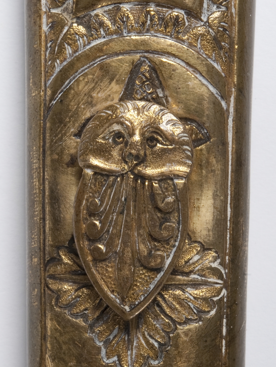 Perlemors-håndtak.  Skjefte m/visirhode, soldat m/gevær, riksvåpen.  Klingen signert " C. M. F. " og  " C XIV J ".
Sliren av lær og messing, liljemerket.