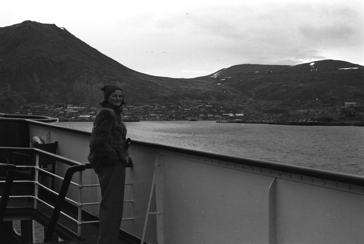 Jusstudent Solveig Hanche-Olsen fotografert ved rekka på Hurtigruta DS Sigurd Jarl med Honningsvåg i bakgrunnen. Bildet er tatt tidlig på sommeren 1946.