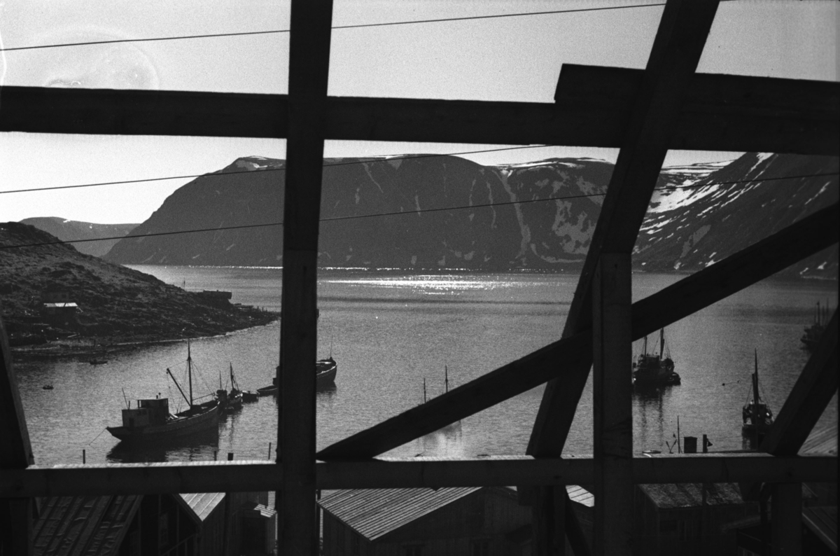 Del av Honningsvåg med havna i forgrunnen.

Arkitekt Ola Hanche-Olsen arbeidet ved Brente Steders Reguleringskontor i 1946. Hovedadministrasjon for gjenreisning av Nord-Troms og Finnmark ble lagt til Harstad og fikk navnet Finnmark kontoret. Landsdelen Nord-Troms og Finnmark blev oppdelt i syv distrikt med hver sin administrasjon. Honningsvåg, distrikt IV, skulle betjene Nordkapp, Lebesby, Porsanger og Karasjok kommune.

Ola Hanche-Olsen har tatt bildene. Han var født 13. mars 1920 i Borre, død 11. februar 1998 i Gjettum. Han var både arkitekt og barnebokforfatter. Han hadde artium fra 1939, arkitekteksamen fra NTH 1946 og arbeidet deretter ved Finnmarkskontoret 1946–48 før han etablerte egen arkitektpraksis. Han debuterte som barnebokforfatter i 1974 med lettlest-boka "Knut og sjørøverne", og skrev i alt 12 bøker. Han var XU-agent 1944-45, og var også en aktiv fjellklatrer og friluftsmann. Ola var gift med Solveig Hanche-Olsen (f. Falkenberg); de fikk 3 barn, blant dem matematikeren Harald Hanche-Olsen.

