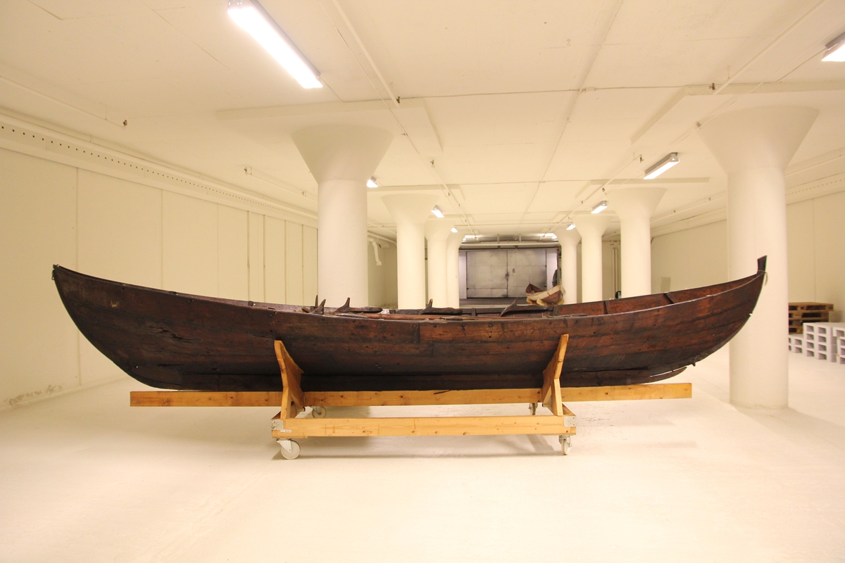 Treroring fra Sunnmøre, med div. løsøre ( 3 par årer, mast og rundholt, tiljer, tofter). Selvgrodde keiper. Råte babord baug.
