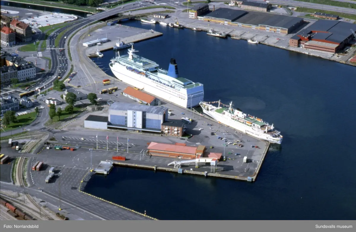 Flygfoton över Sundsvalls hamn med färjeterminalen, färjor, fryshus och omgivande bebyggelse. På den ena bilden syns att Norrmalm var en enda stor parkeringsplats innan P-huset och Teliahuset byggdes.
