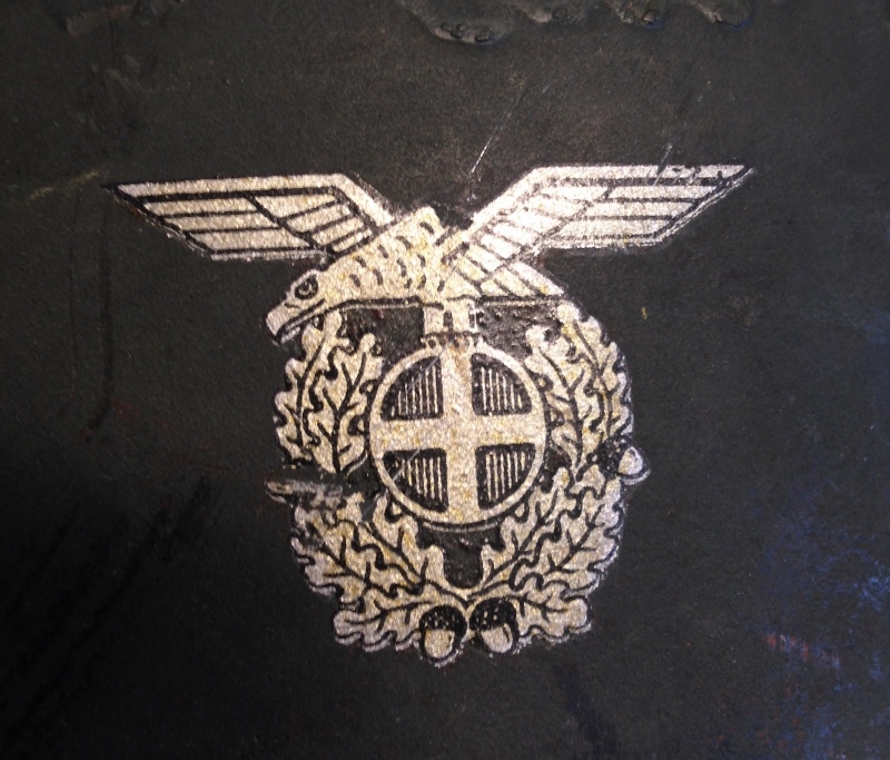 Det norske politimerket 1942-1945: skarv (ørn) med solkors og ekeløvskrans.