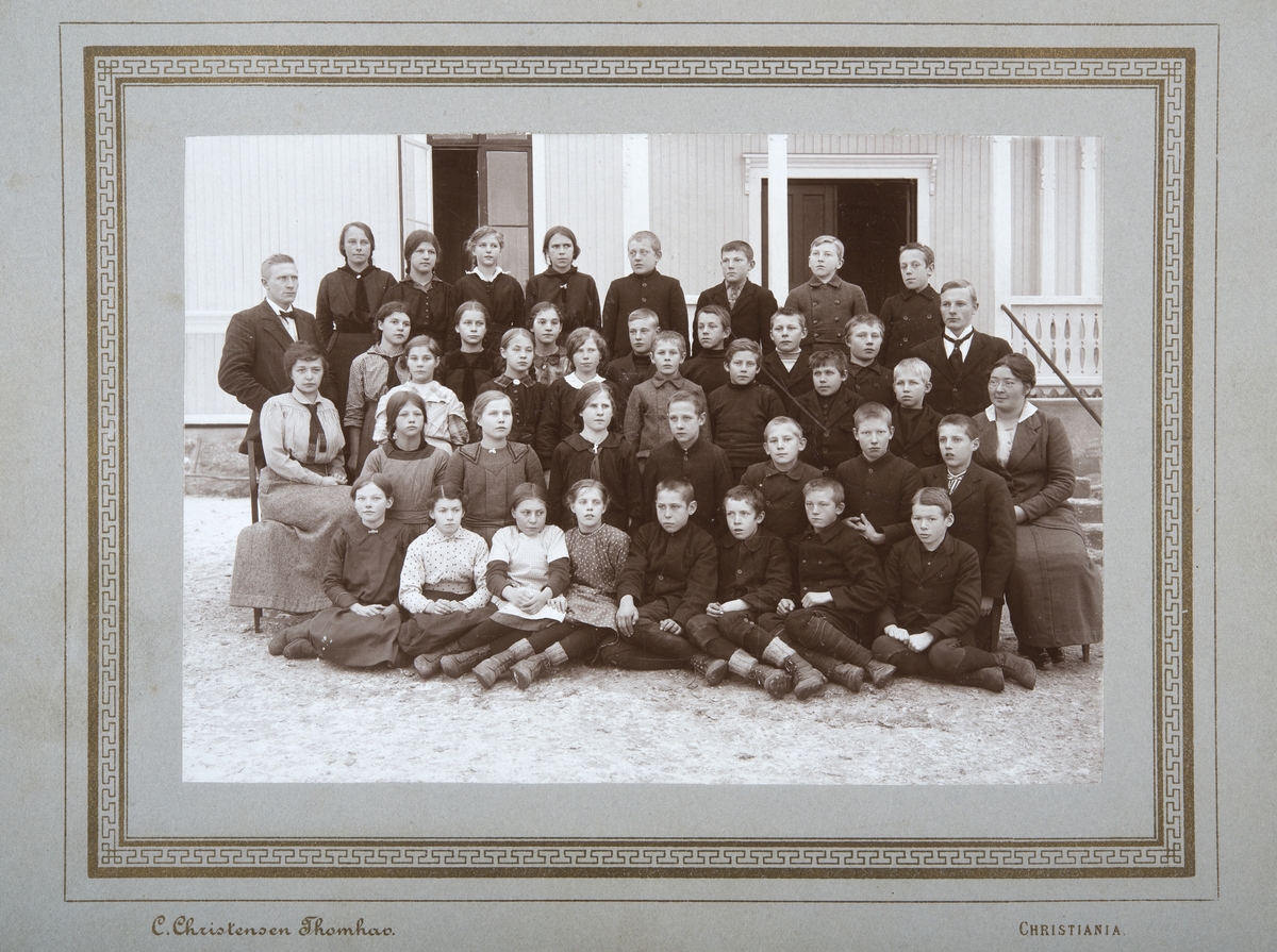 Skolebilde Brovold skole. (Kan dette være 7. og 6. klasse i storskola? 12-14 år gamle) De samme fire lærere, og samme opptakssituasjon som for 0415-03666. Ludvig Zimmermann (lærer Brovold 1911-51, f. 1890), Agnes Bjerke (f.1885, lærer Brovold 1910-1921), Sigvald Holen (lærer Brovold 1914-1920, fra Vegårdshei, f.1893?, senere rektor i Bergen). Agnes Hommelstad (ambulerende husstellærer i Folkeskolen,1916-1919, f.1891, elev på Dystingbo i 1910).
Elevene, Ester Skogen (f.1902) er på bildet, bakerste rad, først fra venstre.