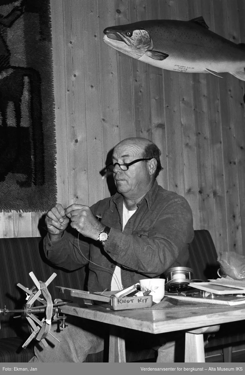 Fluebinding i hytteinteriør.

Fotografert 1982.

Fotoserie: Laksefiske i Altaelva i perioden 1970-1988 (av Jan Ekman).
