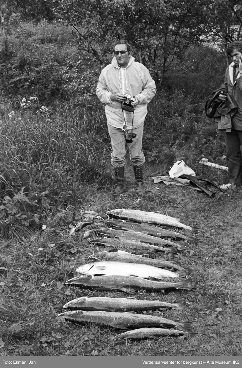 Fangst med personer.

Fotografert mellom 1970 og 1988.

Fotoserie: Laksefiske i Altaelva i perioden 1970-1988 (av Jan Ekman).
