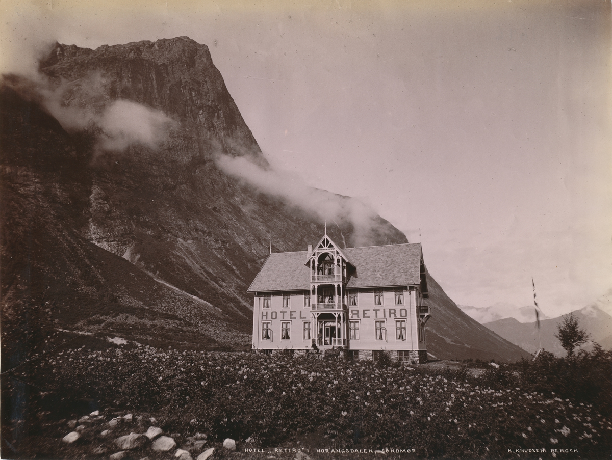 Prospektfotografi av Hotell Retiro i Norangsdalen. En potetåker i forgrunnen.