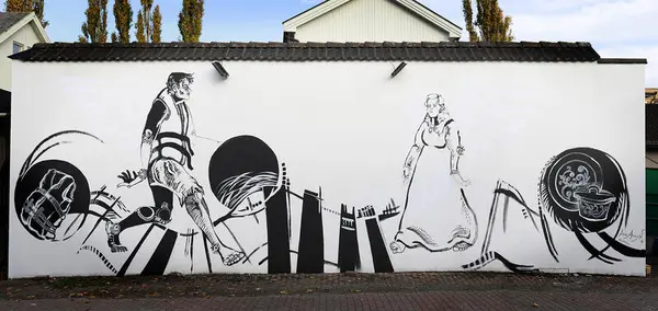 «Drømmer over grenser» er et veggmaleri malt av Lucia Aragon. Det viser en mann med redningsvest som møter en kvinne i bunad. Innvandring møter utvandring.