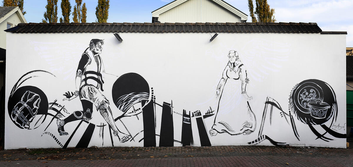 «Drømmer over grenser» er et veggmaleri malt av Lucia Aragon. Det viser en mann med redningsvest som møter en kvinne i bunad. Innvandring møter utvandring.