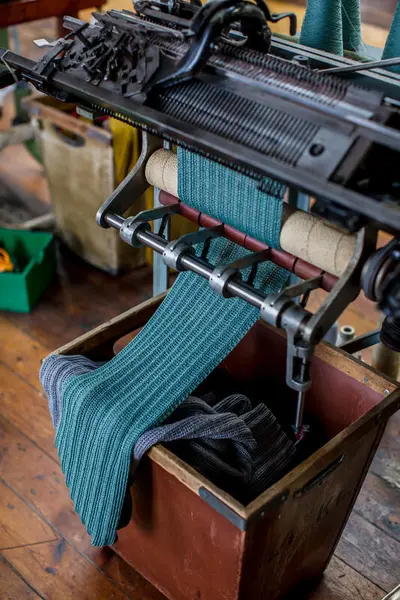 Flatstrikkemaskin strikkar ei turkis stoffremse