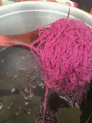 garnfarging: rosa garn i gryte med tresleiv