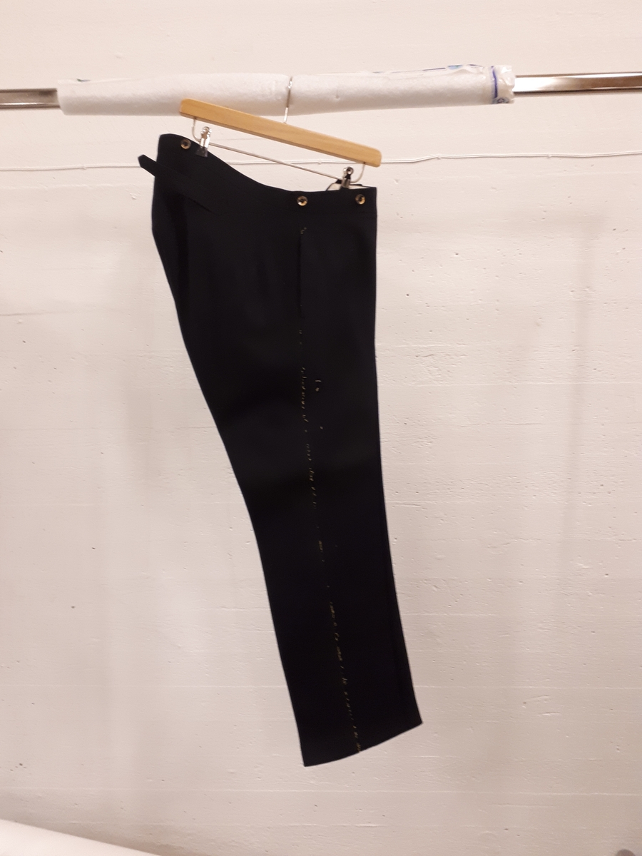 Långbyxor av kläde med spår efter bortsprättade guldgalon för lotskapten med Kungliga lotsverkets emblem och kaptens gradbeteckning.