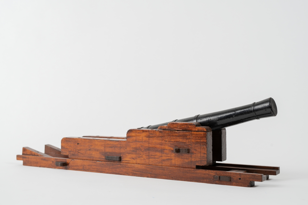 Kanonmodell: 18-pundig blälklavett av Ehrensvärds modell, av trä, med kanon. Lavett L = 560 mm B = 120 mm H = 105 mm.