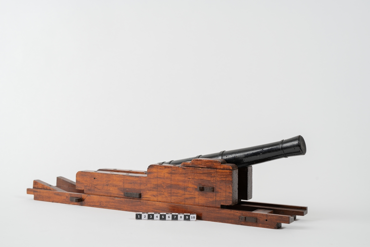 Kanonmodell: 18-pundig blälklavett av Ehrensvärds modell, av trä, med kanon. Lavett L = 560 mm B = 120 mm H = 105 mm.
