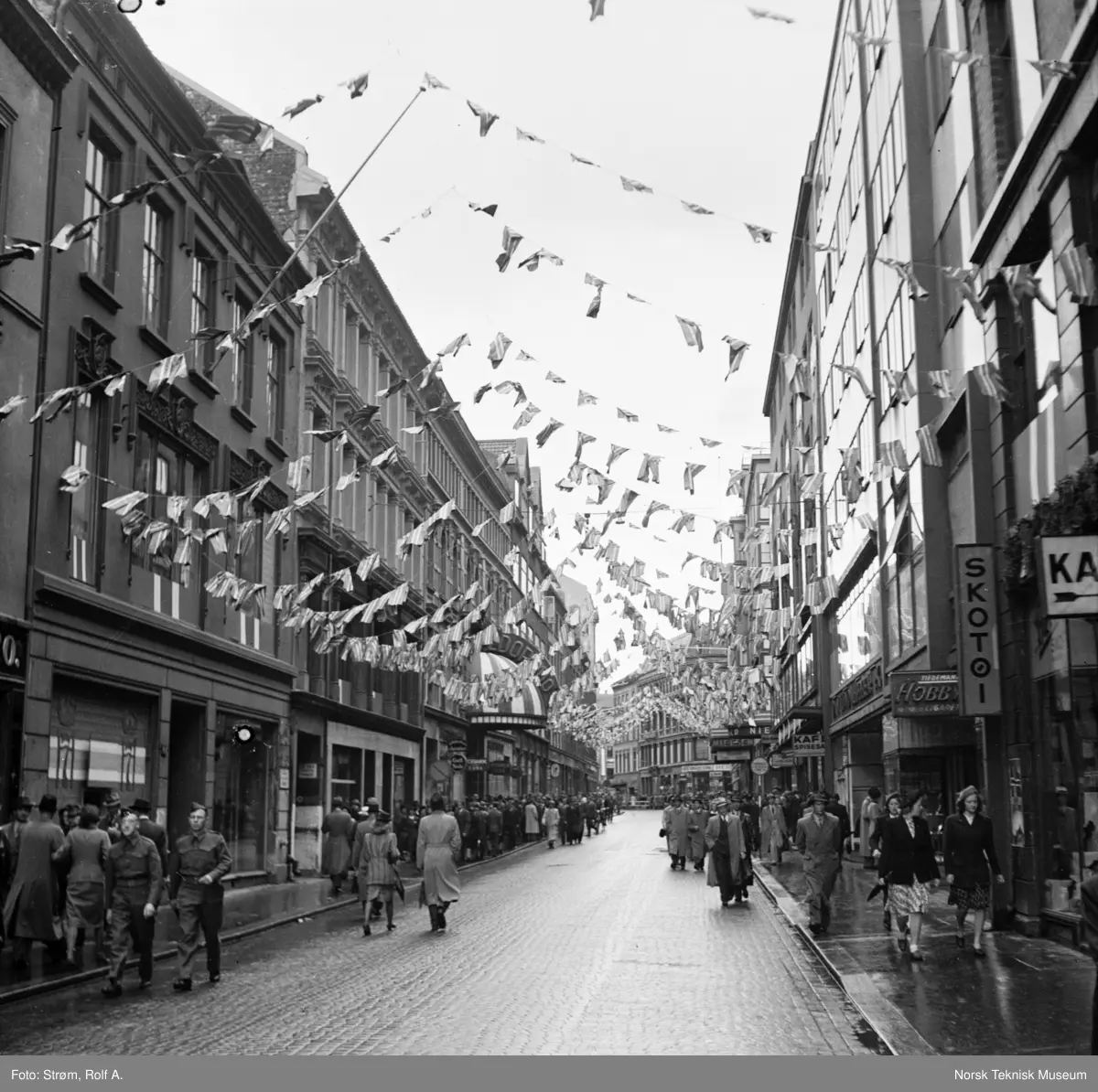 Forberedelser til kong Håkons hjemkomst, Torggata forbi Eldorado kino er pyntet med flagg og Håkon 7's monogrammer i vinduene, juni 1945.