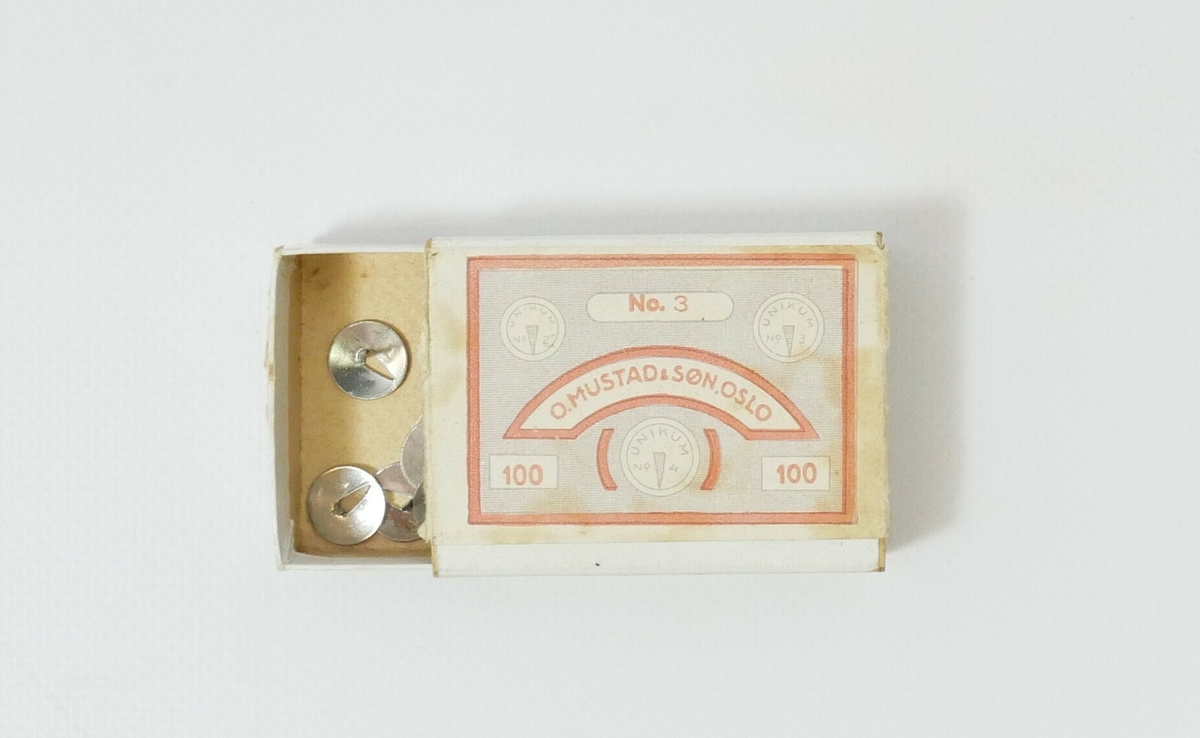 Hvit rektangulær eske i kartong. Inne i esken er det 14 blanke tegnestifter. 

Påskrift, øverst på esken: 
No. 3 // O.MUSTAD &SØN. OSLO // 