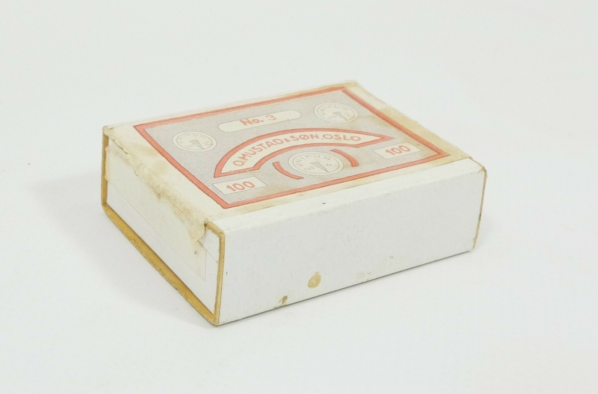 Hvit rektangulær eske i kartong. Inne i esken er det 14 blanke tegnestifter. 

Påskrift, øverst på esken: 
No. 3 // O.MUSTAD &SØN. OSLO // 