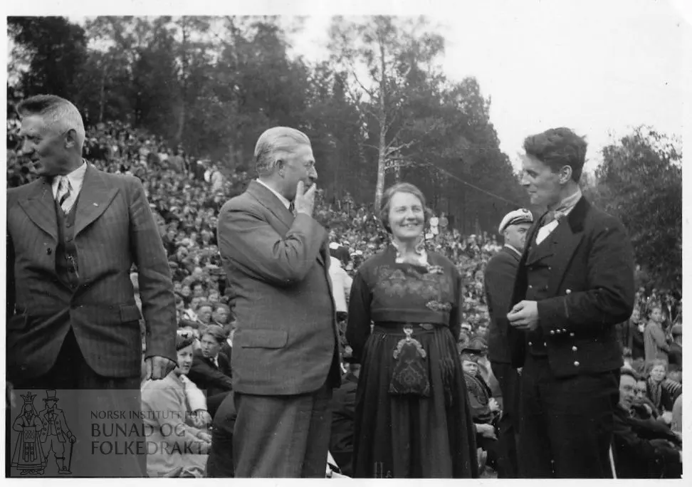 Bilete frå eit stemne i Aasentunet i 1939. Klara Semb midt i biletet er kledd i bunad frå Aust-Telemark. Bunadskledd mann og to i dress står ved hennar side. Det er ei mengd med folk i bakgrunnen.