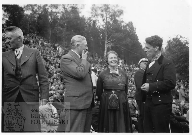 Bilete frå eit stemne i Aasentunet i 1939. Klara Semb midt i biletet er kledd i bunad frå Aust-Telemark. Bunadskledd mann og to i dress står ved hennar side. Det er ei mengd med folk i bakgrunnen.