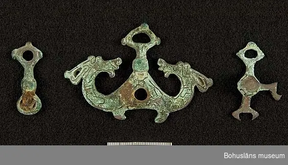 Del av betsel för häst i brons med silverdekor. Föremålen hittades på 1920-talet vid bortforslandet av en större förhöjning på fastigheten Jordhammar Östergård, i Ödsmål socken, Stenungsunds kommun. Förhöjningen var förmodligen en gravhög från yngre järnålder och betslet en del av de gravgåvor som den döde fått med sig (se rapport 1982:37, s.76f).

Ornamentiken på betslet (djurmotiv) tillhör en grupp av spännen med silverdekor som hör till slutet av vikingatiden (ca 900 - 1000 e. Kr). Sammanlagt består fyndet av nio föremål, i både brons och järn, varav vissa kanske inte hör till hästutrustning utan är delar av beslag till skrin eller kista? Vissa av dessa metallföremål har kvar rester efter förgyllning.

Liknande fynd finns på SHM (inv. nr 13703), vilka inkom 1909 från Lundby i Fors socken, Sörmland. Även från Lund i Skåne och på flera platser i södra Danmark har man hittat delar till motsvarande betselutrustningar.

Landskap Bohuslän