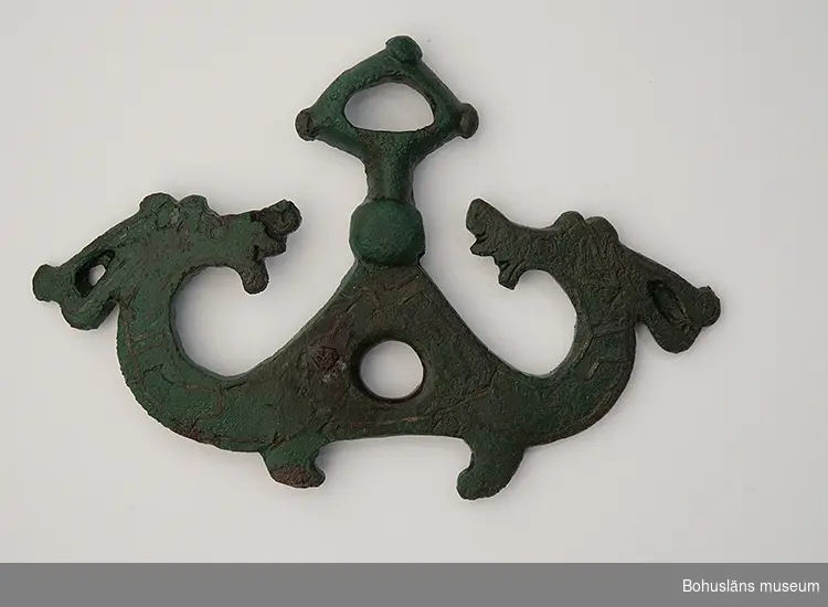 Del av betsel för häst i brons med silverdekor. Föremålen hittades på 1920-talet vid bortforslandet av en större förhöjning på fastigheten Jordhammar Östergård, i Ödsmål socken, Stenungsunds kommun. Förhöjningen var förmodligen en gravhög från yngre järnålder och betslet en del av de gravgåvor som den döde fått med sig (se rapport 1982:37, s.76f).

Ornamentiken på betslet (djurmotiv) tillhör en grupp av spännen med silverdekor som hör till slutet av vikingatiden (ca 900 - 1000 e. Kr). Sammanlagt består fyndet av nio föremål, i både brons och järn, varav vissa kanske inte hör till hästutrustning utan är delar av beslag till skrin eller kista? Vissa av dessa metallföremål har kvar rester efter förgyllning.

Liknande fynd finns på SHM (inv. nr 13703), vilka inkom 1909 från Lundby i Fors socken, Sörmland. Även från Lund i Skåne och på flera platser i södra Danmark har man hittat delar till motsvarande betselutrustningar.

Landskap Bohuslän