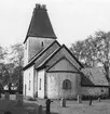 Några människor beundrar utsikten från tornet i Kumlaby kyrka på Visingsö.