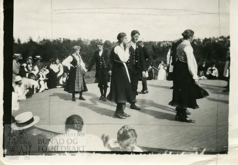 Kvinner og menn i bunad og motedrakt, danser og publikum. Norsk Folkemuseum, Bygdøy.