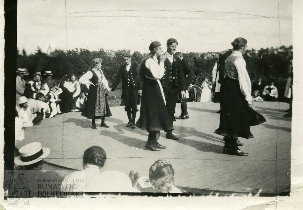 Kvinner og menn i bunad og motedrakt, danser og publikum. Norsk Folkemuseum, Bygdøy.