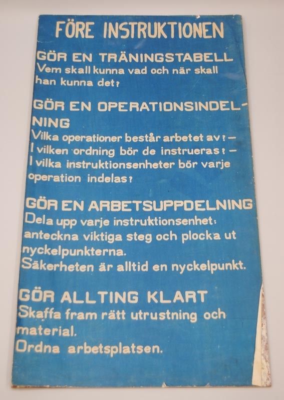 Låda (:1) tillverkad av spontade hyvlade brädor och med plåtförsedda hörn. Lådan är målad i grågrön kulör. Gångjärn, handtag på sidor och stängningsanordningen är av järn. De förstnämnda är inmålad i lådans kulör och övriga är svartmålade. Lådan innehåller utbildningsmaterial, bl.a.  planscher och böcker, och har hört till 14:e Maskinsektionen i Ånge.

Innehåll:
Jvm 20719:2 Längd: 690 mm Bredd: 20 mm Höjd: 425 mm
Personal- arbete- och produktionstavla av trä. Tavlan har flera små hål så att man kan sätta upp namnskyltar och arbetsuppgifter, samt små pluppar i 4 olika färger. Färgerna berättar hur bra en person klarar av utförandet av arbetet. Överdelen av tavlan har repat trä.

Jvm 20719:3 Längd: 310 mm Bredd: 15 mm Höjd: 220 mm
Personal- arbete- och produktionstavla, där ett papper är tejpat på en spånplatta, samt små nålar i 4 olika färger. Färgerna berättar hur bra en person klarar av utförandet av arbetet. Missfärgning av tejpen runt kanterna och håller på att släppa.

Jvm 20719:4 och Jvm 20719:5 Längd: 430 mm Bredd: 5 mm Höjd: 780 mm 2 tavlor med vit text på blå bakgrundspapper som är limmat på en träskiva. Tavlorna beskriver saker som man ska tänka på vid utbildning av personal och har överskrifterna "Före instruktionen" och "Under instruktionen". Båda tavlorna har skador på kanterna där papperet lossnat och böjt sig samt små revor.

Jvm 20719:6 Längd: 800 mm Bredd: 23 mm Höjd: 900 mm
Grön krittavla som är ihopfällbar på mitten och har två små haspar av järn som håller ihop tavlan, samt en järnkedja som handtag.

Lådan innehåller även utbildningsmaterial, träningsscheman och böcker.

Utbildningsmaterial Jvm 20719:7-13.
Blanketter: träningstabeller, gruppregister och träningsrapport, arbetsuppdelning, arbetsinstruktioner, dagsprogram för träning och ”en lång operation” som handlar om svarvning. (Jvm 20719:7)
Plan för utbildning av instruktionsförare för el-rälsbuss litt YCoa6-7. År 1955 (Jvm 20719:8)
Plan för utbildning av RBSF på YC06, Plan för utbildning av motorlokförare, Plan för utbildning av förare på Yo, Yo1, Yo1s. År 1954 (Jvm 20719:9)
Systematiserad utbildning. År 1954 (Jvm 20719:10)
Kursmateriel för 10 man. (Jvm 20719:11)
TIF-ärenden: Utbildning i arbetsinstruktion, operationsindelning, arbetsanalys, förslag till företagsledningens introduktion av tränare. (Jvm 20719:12)

Kursdeltagare med studiemateriel: 
Problemlösningskarta vid lok fel, Anteckningar, D-lok högspänningskrets, Förreglingstabell för D-lok. 
(Jvm 20719:13)

Träningsscheman Jvm 20719:14-68.
Förare på ellokomotor, litt Za, 1 blad (Jvm 20719:14)
Förare på Yo, Yo1, Yo1s, 1-9 blad + 1 kopia på bladen 1-4 (Jvm 20719:15-27)
Lokomotorförare, 1-4 blad (Jvm 20719:28-31)
Motorfordons rpr på YCo6, 1-6 blad (Jvm 20719:32-37)
Motorlokförare, 1 blad + 1 kopia (Jvm 20719:38-39)
Signalskolan, 1-4 blad (Jvm 20719:40-43)
Teknisk vagntjänst, 1-3 blad + 1 kopia på alla blad (Jvm 20719:44-49)
Teleskolan, 1-4 blad (Jvm 20719:50-53)
Ånglok- till ellok rpr, 1-3 blad + 4 kopior av alla blad (Jvm 20719:54-68)

Böcker Jvm 20719:69-84.
Arbetsuppdelningar för förare "“ Y Bo6. År 1958
(Jvm 20719:69)
Sammanfattning av de viktigaste bestämmelserna för befordring av explosiva varor på järnvägen. År 1954 
(Jvm 20719:70)
Bestämmelser angående företagsnämnder vid SJ. + 1 kopia. År 1954 (Jvm 20719:71-72)
Plan för utbildning av motorlokförare. + 1 kopia. År 1953 (Jvm 20719:73-74)
Plan för utbildning av RBSF på YC06. År 1953 
(Jvm 20719:75)
Plan för utbildning av förare på Yo, Yo1, Yo1s. /Del A/ År 1953(Jvm 20719:76)
Plan för utbildning av lokbiträden vid 6 ms + träningsschema. År 1952-1953 (Jvm 20719:77-78)
Plan för utbildning av tkl (praktisk) vid 6 ts. + träningsschema. År 1952 (Jvm 20719:79-80)
Drifttekniska bestämmelser för den rullande materielen vid SJ
normalspåriga bandelar. Avd. Bt. Tryckluftbroms År 1949 (Jvm 20719:81)
Elektrolok Öd. År 1948 (Jvm 20719:82)
Elektrolok M. År 1947 (Jvm 20719:83)
Anvisningar och exempel ang. Bromskraft i tåg utarbetad av
Carl Viksten stationsinspektor. År 1944 (Jvm 20719:84)

Pärmar Jvm 20719:85-87.
TIF studiemateriel. (Jvm 20719:85)
Röd pärm, blanketter för arbetsuppdelning och Pm angående träningstabell (Jvm 20719:86)
Svart pärm, blanketter för arbetsuppdelning, arbetsinstruktioner och dagsprogram för träning. (Jvm 20719:87)