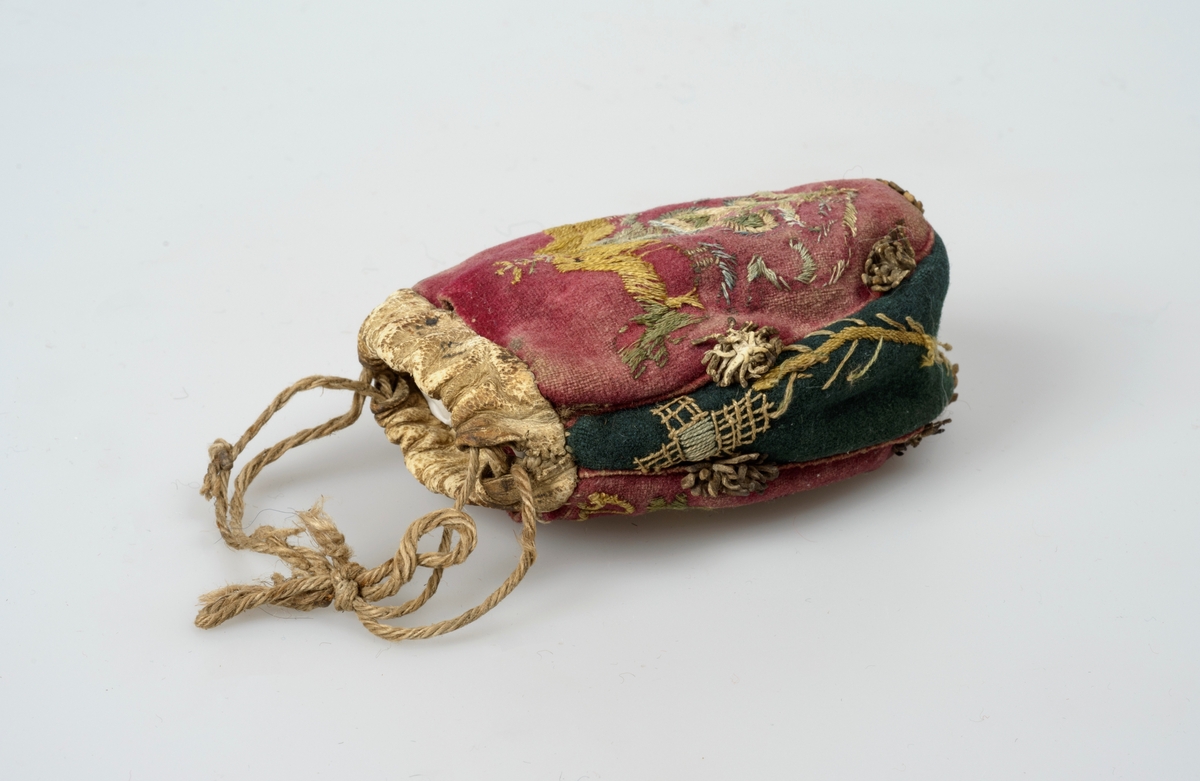 Pungen er brodert med et fuglemotiv på begge sider. Øverst til høyre på den ene sida er det også brodert et årstall.