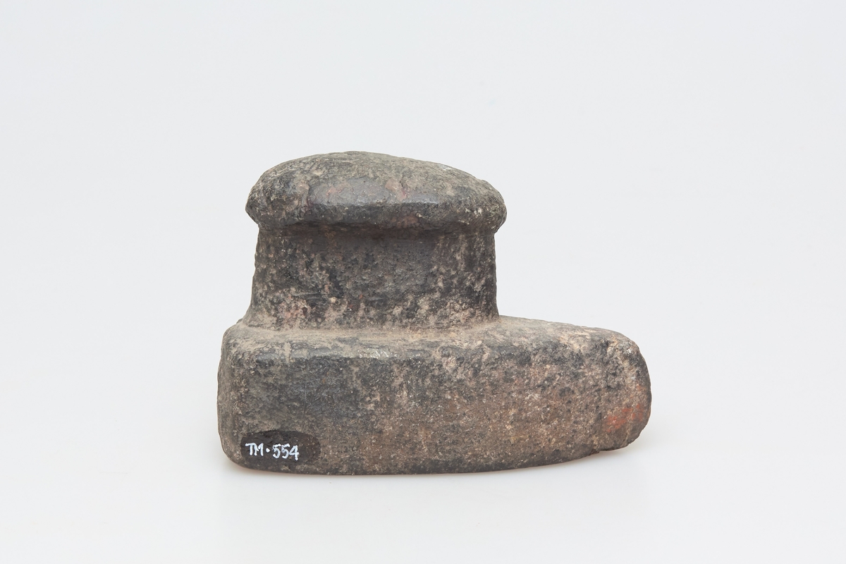 Glattesteinen er formet som et strykejern, tilspisset og med et håndtak