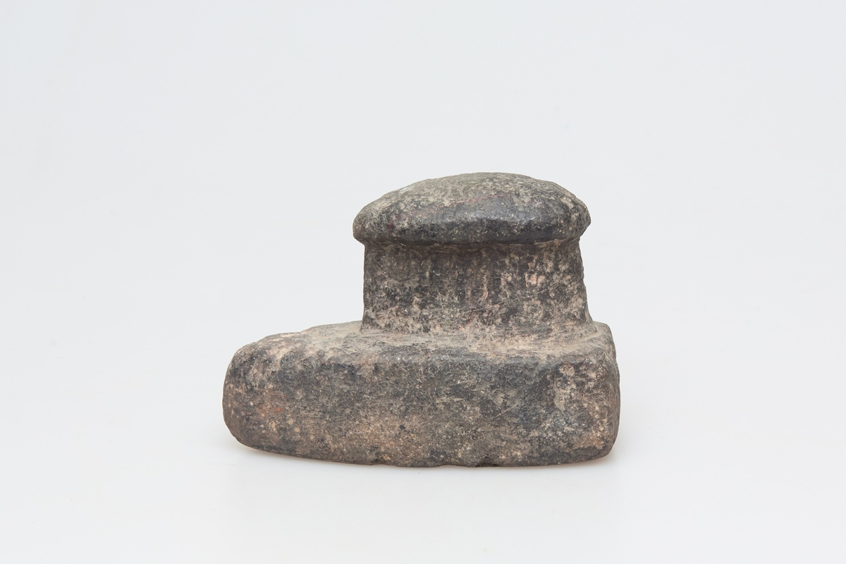 Glattesteinen er formet som et strykejern, tilspisset og med et håndtak