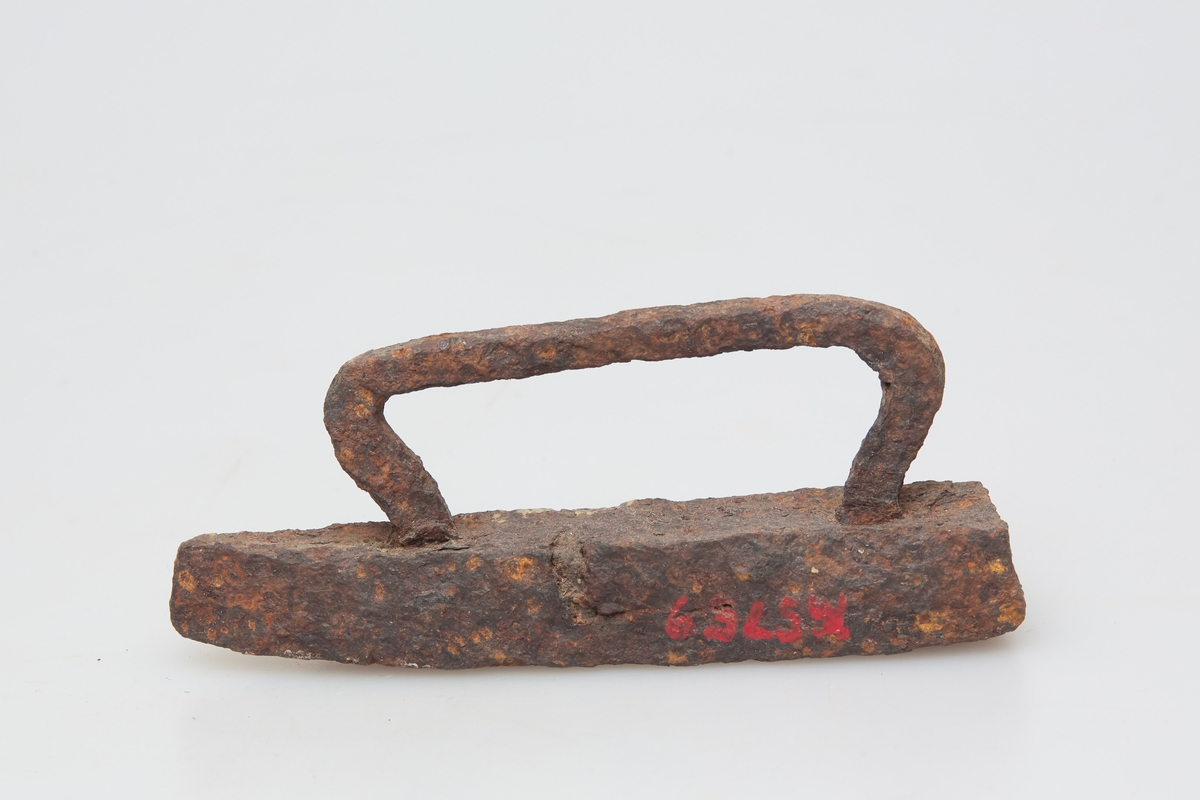 Særdeles lite strykejern med håndtak av jern. Håndsmidd, noe grovt utformet, rustent. Sjelden type, leketøy?