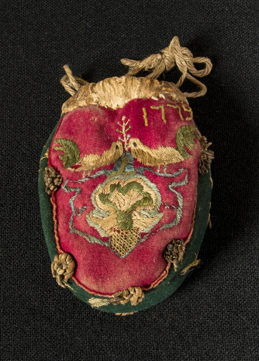 Pungen er brodert med et fuglemotiv på begge sider. Øverst til høyre på den ene sida er det også brodert et årstall.