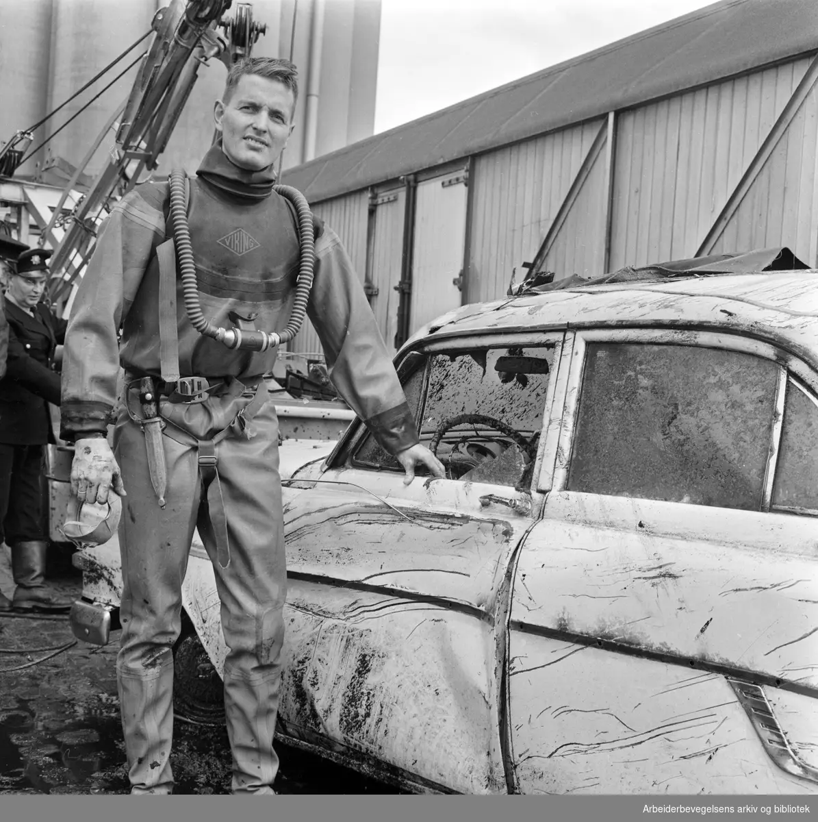 Dykkere fra Oslo Brannvesen heiser i land et bilvrak ved kaia på Vippetangen. August 1962.