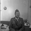 Porträtt av hemvärnschef Knut Linné i hemvärnsuniform. Fotograferad i hemmiljö.