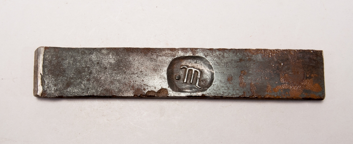 Järnstämpel från Sonstorp. Stämpeln är ett litet "m" med en punkt på varsin sida. även på baksidan. Har numret 344 instansat på ena kortsidan.