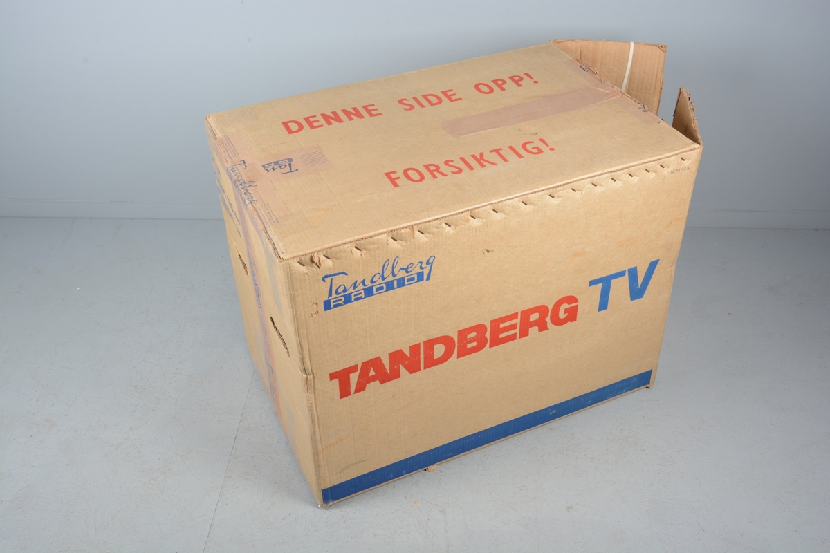 Fjernsynsapparat frå Tandberg. Straumleidning på baksida. Kassen står på to doble bein - eitt sett på kvar kortside av fjernsynet, forsterka med ei fram- og ei baksprosse. Antenneleildning og monteringsskruer og original emballasje følger med.