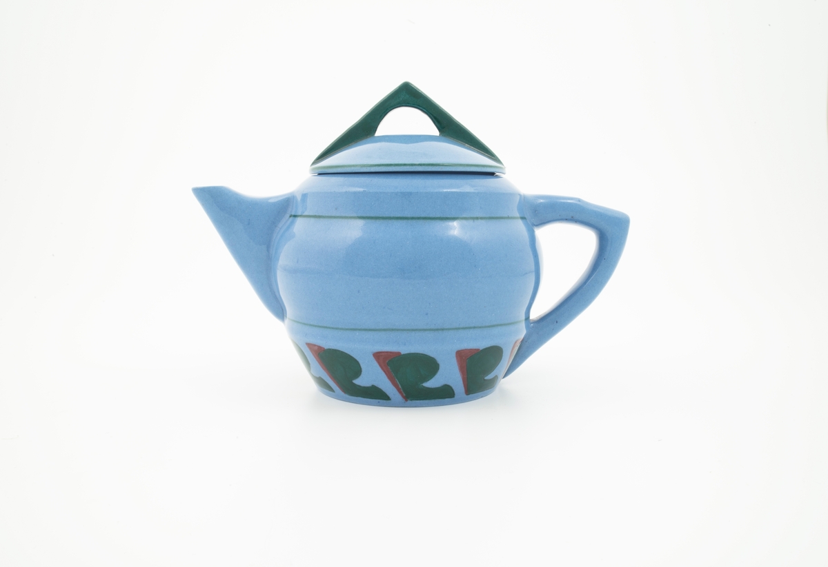 Tekanne med lokk i glasert steingods med begitning. Tilnærmet kuleformet lyseblått korpus med påsatt vinkelformet hank, samt en smal trekantformet tut med sirkulær åpning. Nedre del av korpus er dekorert med en stilisert bord i grønt og rødt. Horisontale grønne linjer understreker kannens form. Den avsluttes med et sirkulært lokk som krones med en triangulær grønnfarget lokknapp.