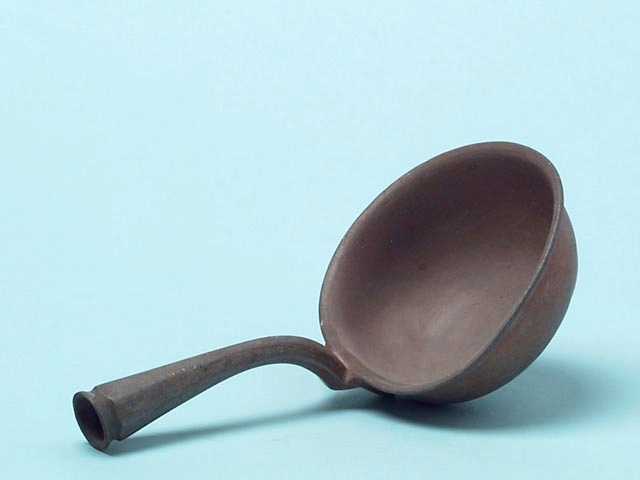 Av metall; kort skaft av samma material; det längre träskaftet saknas.
Förläggssked?